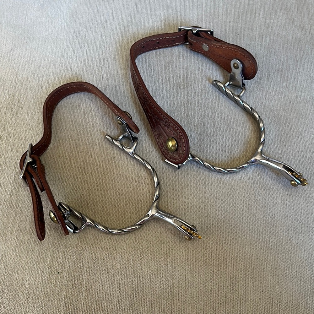 Western spurs with brown leather tooled spur straps